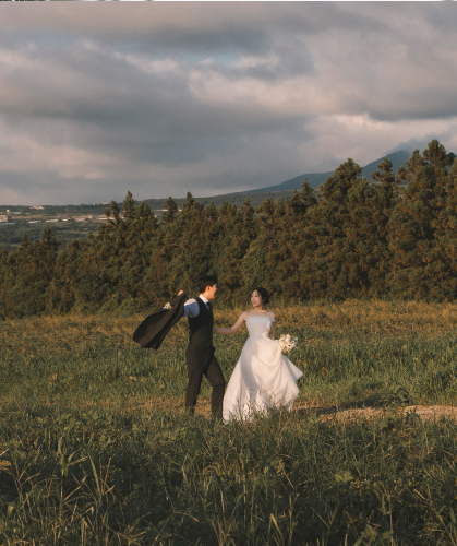 제주 초원에서 손을 맞잡고 걷는 필레코드 웨딩 스냅